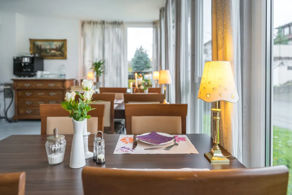 Frühstücksraum mit gedeckten Tischen und Stehlampe